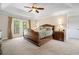 Spacious main bedroom with a tray ceiling, ceiling fan, and french doors leading to a private balcony at 5144 Rishley Run Way, Mount Dora, FL 32757