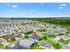 An aerial view shows the home in a neighborhood setting with lawns, ponds, and mature trees at 5868 Wood Stork Way, The Villages, FL 32163