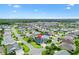 Aerial view of the home and surrounding neighborhood, featuring lush landscaping and well-maintained lawns at 5868 Wood Stork Way, The Villages, FL 32163