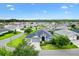 Stunning aerial view of a well-maintained home with lush landscaping and a three-car garage in a desirable community at 5868 Wood Stork Way, The Villages, FL 32163