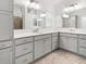 Spacious bathroom featuring dual sinks, gray cabinets and a walk-in shower at 5868 Wood Stork Way, The Villages, FL 32163