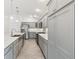 This kitchen features a large island, stainless steel appliances, gray cabinets, and spacious countertops at 5868 Wood Stork Way, The Villages, FL 32163