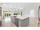 Kitchen boasts an island with a sink, stainless steel appliances, and views of the sunroom through sliding glass doors at 5868 Wood Stork Way, The Villages, FL 32163