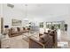 Spacious living room featuring elegant furnishings, an open floor plan, and a modern kitchen view at 5868 Wood Stork Way, The Villages, FL 32163
