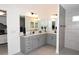 Spacious primary bathroom showcasing double vanity, modern fixtures, and a walk-in shower with gray tiling at 6301 Danielson Loop, The Villages, FL 32163