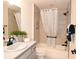 Bright bathroom featuring a shower-tub combo, neutral tile surround, and a vanity with a white countertop at 6301 Danielson Loop, The Villages, FL 32163