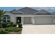 Front of a lovely one-story home with a well-maintained lawn and two-car garage at 6301 Danielson Loop, The Villages, FL 32163