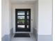 Stylish front door with glass panels and a welcoming entryway with black doormat at 6301 Danielson Loop, The Villages, FL 32163