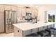 Modern kitchen with stainless steel appliances, quartz countertop, and breakfast bar at 6301 Danielson Loop, The Villages, FL 32163