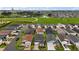 Aerial view of a well-maintained neighborhood with green spaces, roadways and community pond at 6342 Whittle Ct, The Villages, FL 32163