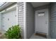Close-up featuring a well-lit front door with stylish grey siding and white trim at 6342 Whittle Ct, The Villages, FL 32163