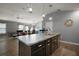 Kitchen island with seating, sink, and open floor plan at 6342 Whittle Ct, The Villages, FL 32163