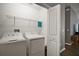Laundry room with white washer and dryer, wire shelving and white walls at 6342 Whittle Ct, The Villages, FL 32163