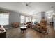 Bright living room with comfortable seating, hardwood floors, and modern décor flowing into the dining area at 6342 Whittle Ct, The Villages, FL 32163
