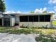Exterior view of backyard including a screened in porch, storage shed, and some landscaping at 679 Avenue Q Se, Winter Haven, FL 33880