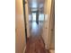 Hallway with wood-look flooring, leading to a bright door at the end at 679 Avenue Q Se, Winter Haven, FL 33880
