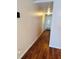Hallway with wood flooring, doors leading to various rooms, and visible electrical outlets on the walls at 679 Avenue Q Se, Winter Haven, FL 33880