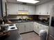 Well-lit kitchen features white cabinets, a double basin sink, and stainless steel appliances at 679 Avenue Q Se, Winter Haven, FL 33880