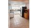 Bright kitchen with white cabinets, stainless steel refrigerator, and tile floor at 679 Avenue Q Se, Winter Haven, FL 33880