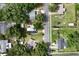 Aerial view of a neighborhood featuring houses, streets, and a canopy of mature trees at 780 N Kentucky Ave, Umatilla, FL 32784