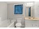 Full bathroom with tub, white vanity, wood look flooring, and natural light at 780 N Kentucky Ave, Umatilla, FL 32784