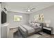 This staged bedroom features neutral walls, a ceiling fan, and large windows for ample natural light at 780 N Kentucky Ave, Umatilla, FL 32784