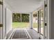 Enclosed porch with white walls, screened windows, and a view of the lush backyard at 780 N Kentucky Ave, Umatilla, FL 32784