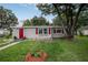 Inviting single story home with a red front door and charming flower boxes at 780 N Kentucky Ave, Umatilla, FL 32784