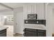 Bright kitchen featuring white cabinetry, black tiled backsplash, gray countertops, and modern microwave at 780 N Kentucky Ave, Umatilla, FL 32784