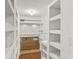 Walk-in pantry with white shelving and terracotta tile floor, offering ample storage space at 780 N Kentucky Ave, Umatilla, FL 32784