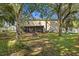 View of the backyard with a screened-in patio area, fire pit, and mature trees at 800 Daybreak Dr, Fruitland Park, FL 34731