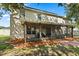 Back of house shows an outdoor patio underneath the shade with view of the fenced backyard at 800 Daybreak Dr, Fruitland Park, FL 34731