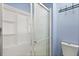 Clean bathroom featuring a frosted glass shower door, white shower and toilet, and a wall mounted towel hanger at 800 Daybreak Dr, Fruitland Park, FL 34731
