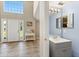 Foyer showing a half bathroom with blue walls and a gray vanity at 800 Daybreak Dr, Fruitland Park, FL 34731