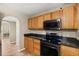 Kitchen with wooden cabinets, black countertops, and stainless steel appliances at 800 Daybreak Dr, Fruitland Park, FL 34731