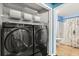 Convenient laundry closet with wire shelving and modern, front-loading washer and dryer at 800 Daybreak Dr, Fruitland Park, FL 34731