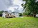 Expansive backyard with a swimming pool, patio area, deck, and lush green lawn at 8203 Bluestar Cir, Orlando, FL 32819