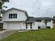 Inviting two-story home with a manicured lawn and a white exterior at 8203 Bluestar Cir, Orlando, FL 32819