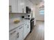 Bright kitchen features white cabinetry with gold hardware and stainless steel appliances at 8203 Bluestar Cir, Orlando, FL 32819
