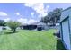Expansive backyard with a well-maintained lawn, screened porch, and space for outdoor activities at 8489 Se 158Th Pl, Summerfield, FL 34491