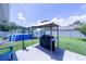 Backyard features include a pool, shed, covered grill and green grass at 8489 Se 158Th Pl, Summerfield, FL 34491