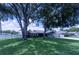 Charming home with mature trees, a well-manicured lawn, and a welcoming facade at 8489 Se 158Th Pl, Summerfield, FL 34491