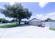 Picture of home's exterior highlighting a large driveway and mature tree at 8489 Se 158Th Pl, Summerfield, FL 34491
