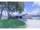 Charming single-story home featuring well-manicured lawn, mature trees, and attached two-car garage at 8489 Se 158Th Pl, Summerfield, FL 34491