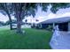 A charming single-story home with a lush green lawn, screen enclosed porch and mature trees at 8489 Se 158Th Pl, Summerfield, FL 34491