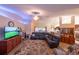 Spacious living room featuring plush seating, a modern entertainment center, and an open floor plan at 8489 Se 158Th Pl, Summerfield, FL 34491