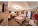 Comfortable main bedroom featuring a tray ceiling, floral bedding, neutral colors, and soft lighting at 8489 Se 158Th Pl, Summerfield, FL 34491