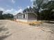 A single-story home with grey siding, white trim, and a small entry staircase at 892 Se 124Th Ave, Webster, FL 33597