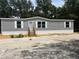 Charming single-story home featuring gray siding, white trim, and well-maintained landscaping at 892 Se 124Th Ave, Webster, FL 33597