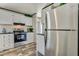 Modern kitchen showcasing a stainless steel refrigerator, white cabinets, and stylish flooring at 892 Se 124Th Ave, Webster, FL 33597